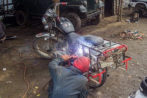 arc welding repair on bullet motorbike rack (india), 350cc, arc welding, fixing, luggage rack, man, mechanic, motorcycle, repairing, royal enfield bullet, sikkim, thunderbird, welder, worker, working