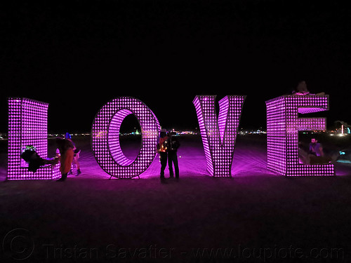 burning man - love sculpture - giant letters, big words, burning man at night, glowing, large words, letters, love, metal sculpture, pink, word
