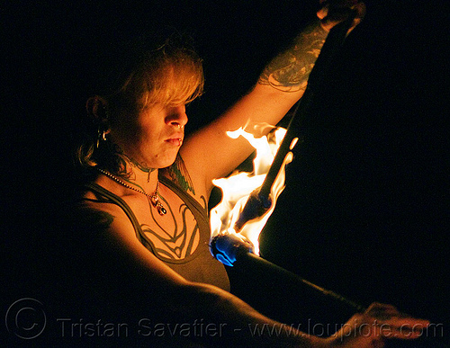 looking at fire staves - leah, fire dancer, fire dancing, fire performer, fire spinning, fire staffs, fire staves, leah, night, tattooed, tattoos, woman
