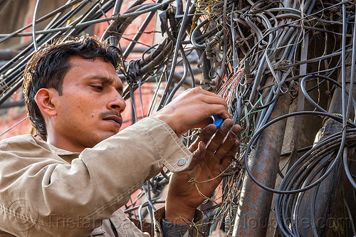 man installing telephone wiring (india), delhi, electric, electricity, man, phone lines, street pole, tangled, technician, telephone, wires, wiring, worker, working
