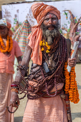 sadhu with ritual rudraksha beads necklaces - kumbh mela (india), baba, beard, cellphone, headwear, hindu pilgrimage, hinduism, kumbh mela, man, marigold flowers, mobile phone, necklaces, rudraksha beads, sadhu