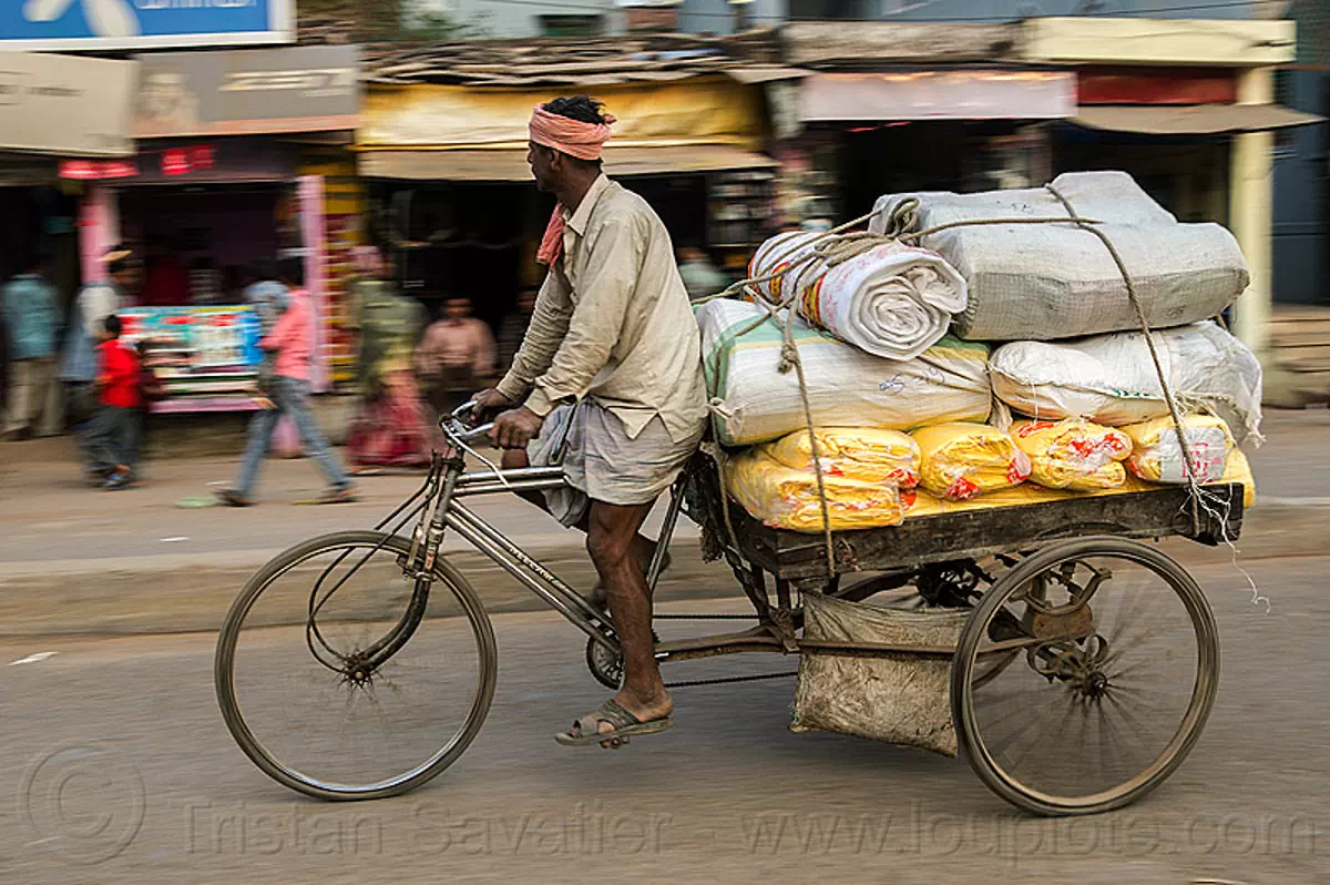 man riding freight tricycle, india