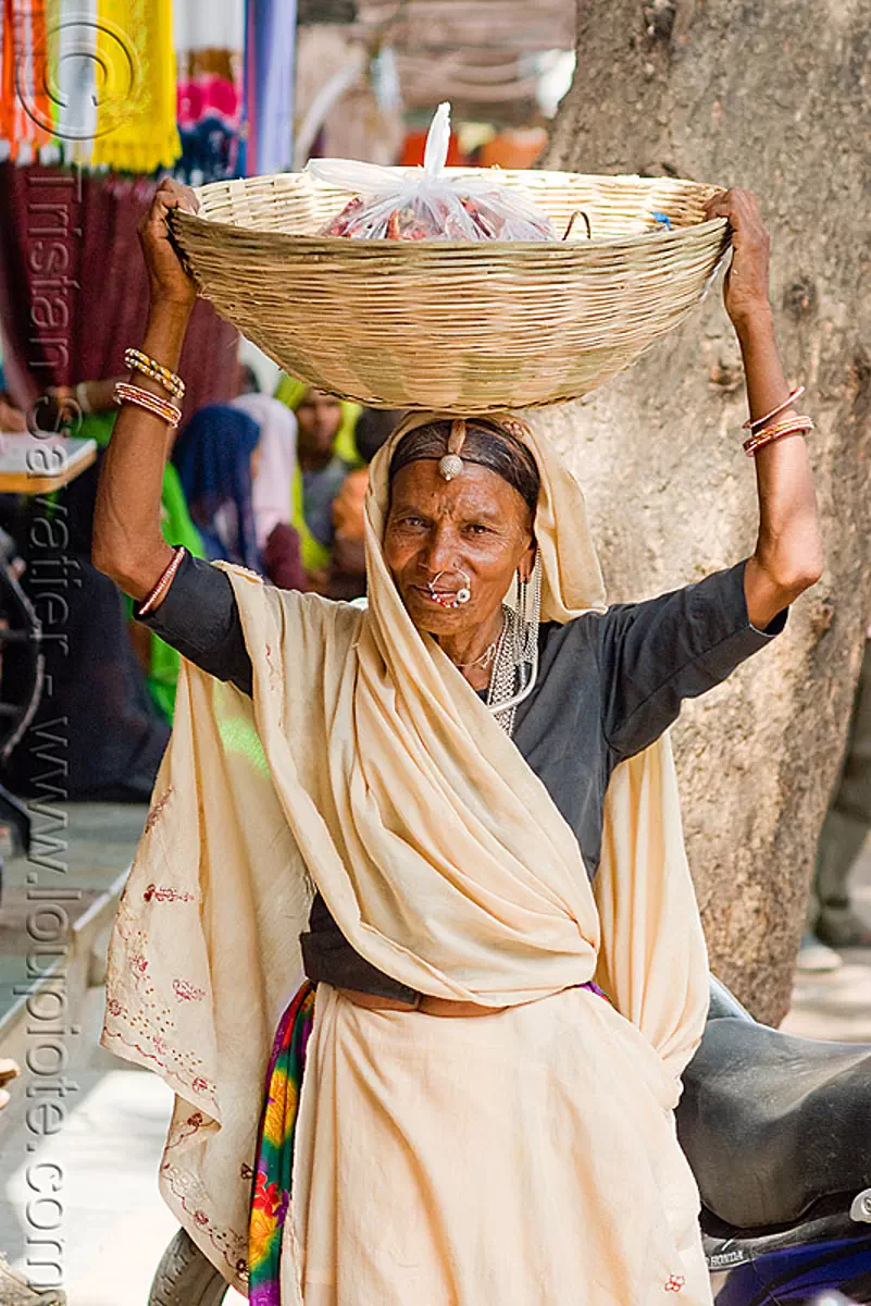 hindu woman carrying basket on head, india