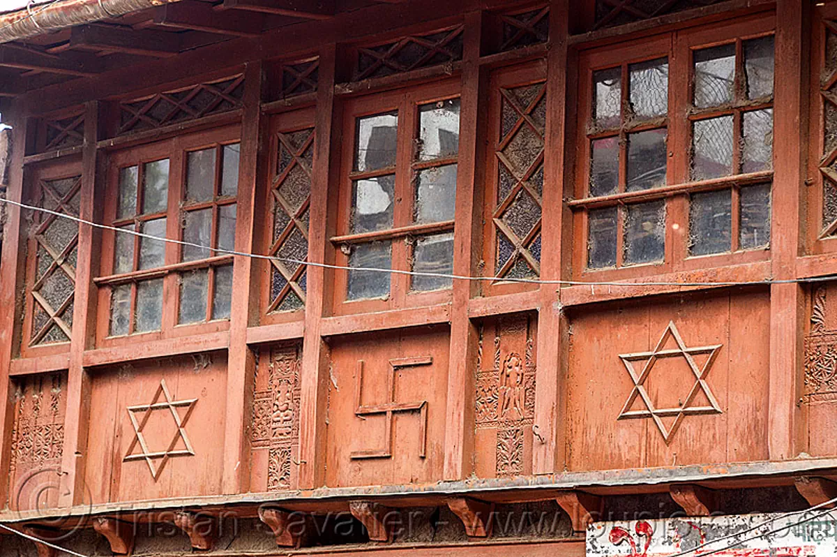 house with hindu symbols, shatkona (star of david) and swastika, india