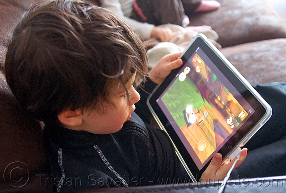 kid playing a video game on an iPad