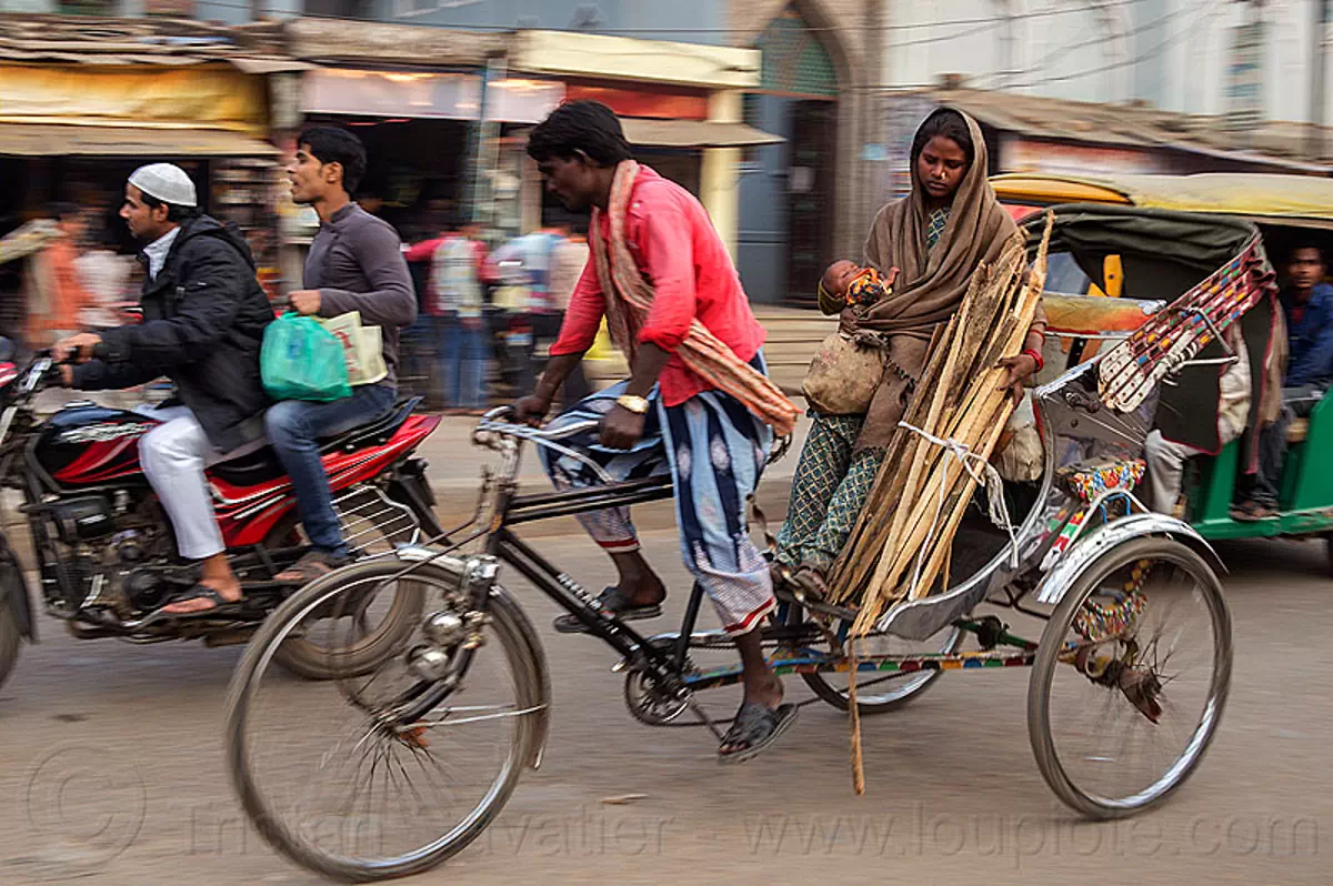 mother and baby on cycle rickshaw, india