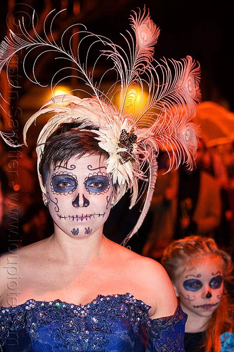 mother and daughter with sugar skull makeup, white feather headdress