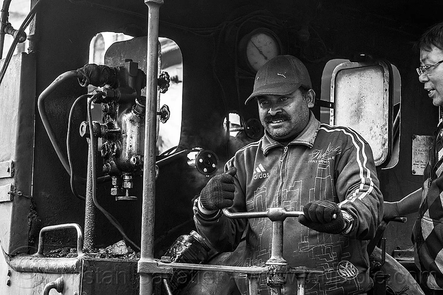 operator at the controls of steam locomotive, darjeeling, india