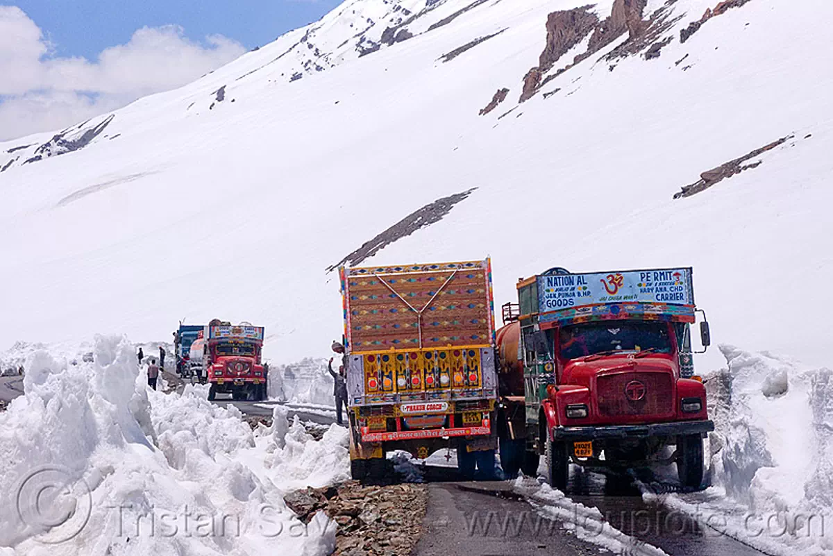 trucks passing each other on narrow mountain road, manali to leh ...