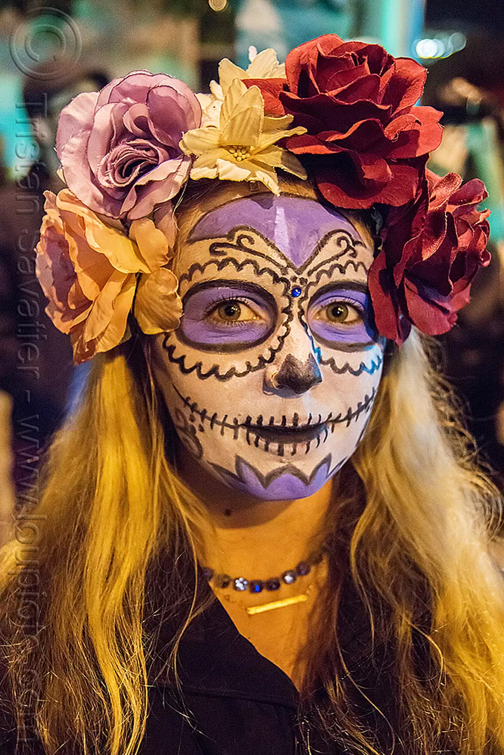 woman with purple and white sugar skull makeup and flower headdress