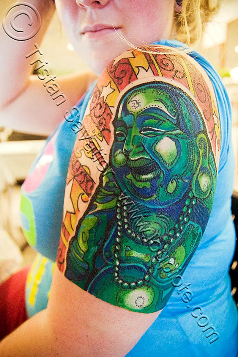 Black and grey Buddha tattoo on the upper arm.
