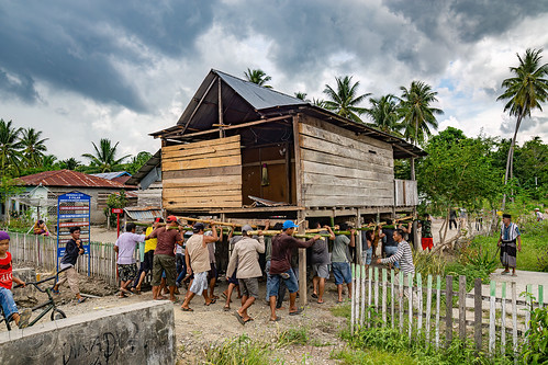 house moving - people carry a house to a new street, crowd, house relocation, men, road, structure relocation, village
